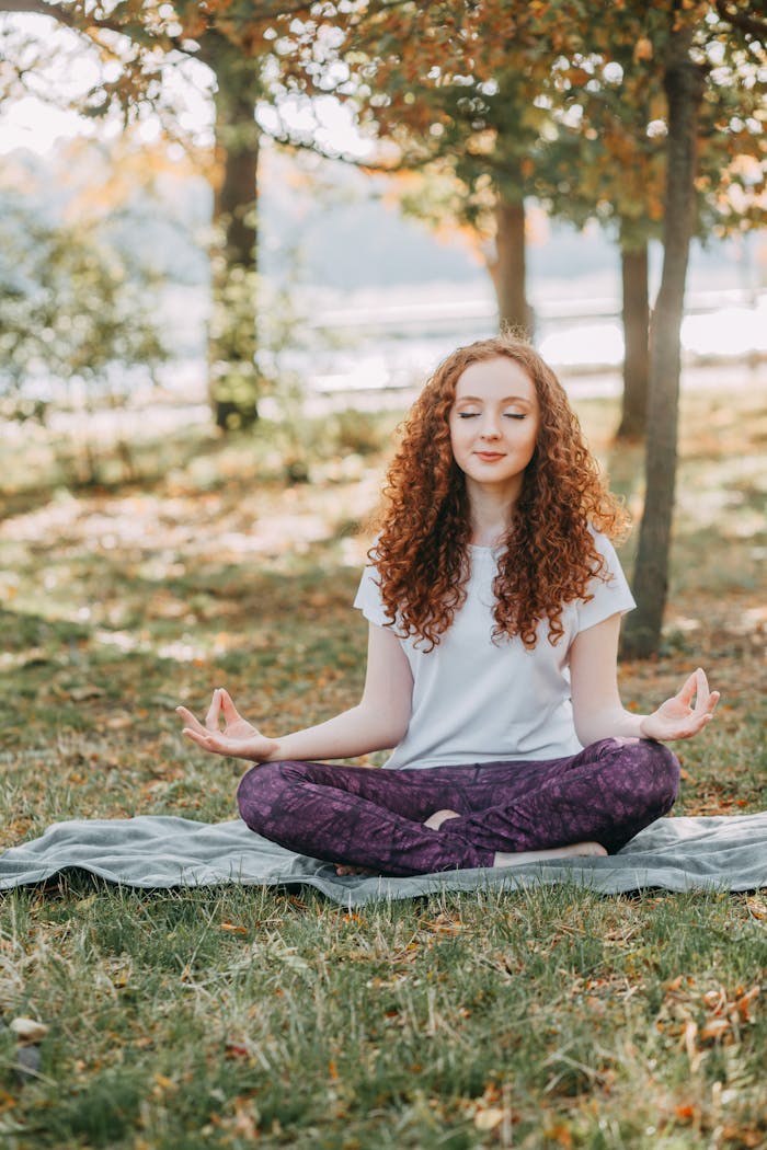 services-04 Woman meditating in a serene park during springtime, fostering relaxation and mental wellness.